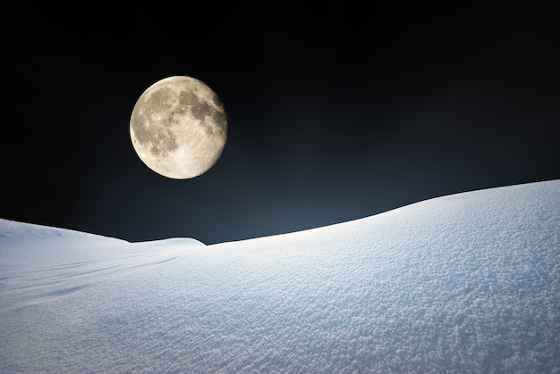 Schneehügel und tiefblauer Himmel im Mondlicht