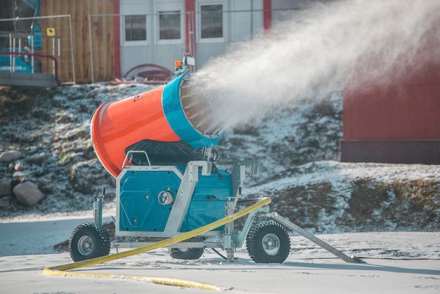 Schneekanone in den Winterbergen. Schneekanone, die künstliche Eiskristalle sprüht. Maschinen, die Schnee machen.