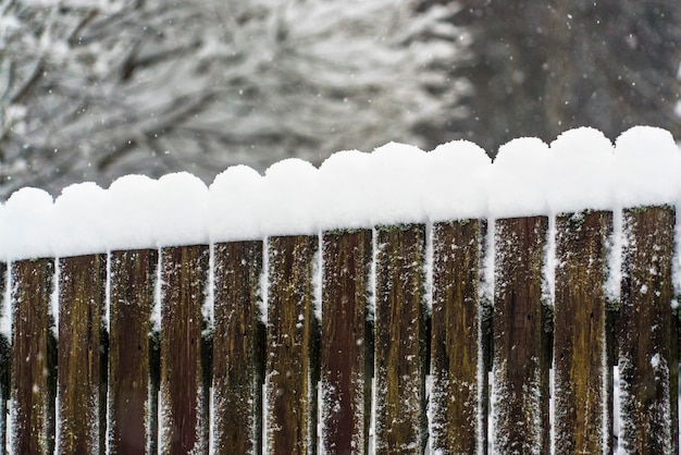 Schneekappen auf einem Holzzaun.