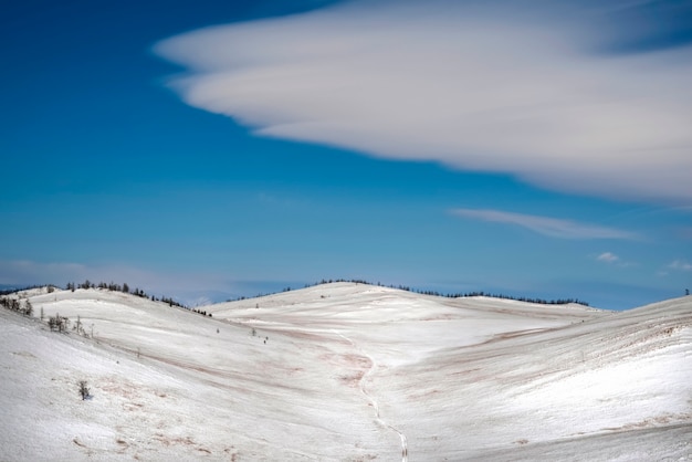 Schneelandschaft des Winters mit linsenförmigen Wolken, blauer Himmel. Desktop-Hintergrund Irkutsk Region, Russland