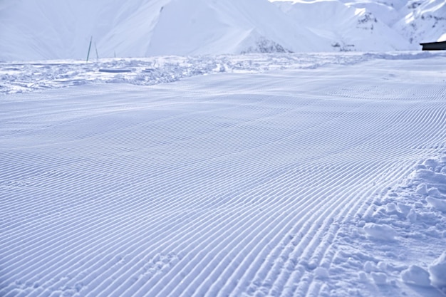 Schneelinien nach Snowtrack im Skigebiet Frisch bereite Skipiste sieht aus wie Samtschnee Gepflegte Skipiste