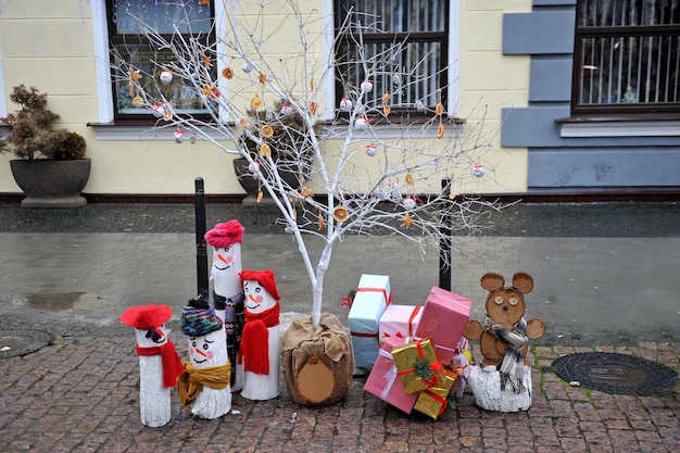 Schneemänner und ein handgemachter hölzerner Teddybär, der mit Geschenken steht.