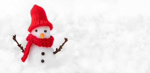 Schneemann im roten Hut auf Winterschnee