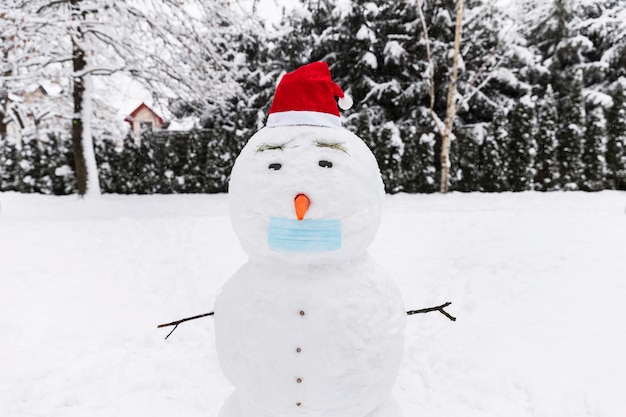 Foto schneemann in einer medizinischen schutzmaske im wald