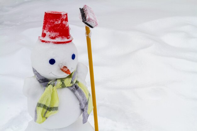 Schneemann in roter Mütze und Schal von Kindern gemacht. Nahaufnahme, vorgewählter Fokus