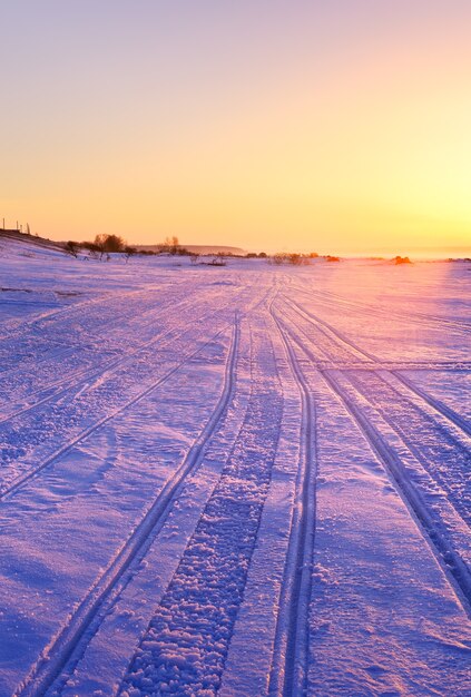 Schneemobilspuren im Schnee am Winterufer des Nowosibirsk-Stausees am frühen Morgen