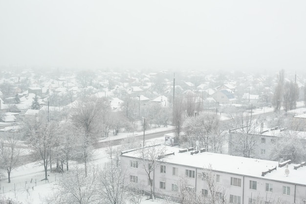 Schneesturm in einer kleinen Stadt, alles ist mit weißem Schnee bedeckt.