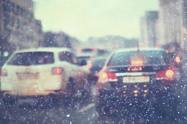 schneetransportstraße stadt/landschaft in einer nächtlichen stadt im winter, autos auf der straße im stau bei kaltem wetter, schnee