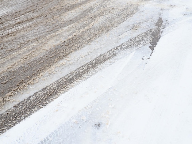 Schneeverwehungen am Straßenrand Schlechtes Wetter und Verkehr Schnee auf Asphalt Schwierige Fahrbedingungen Winterschwappen auf der Straße Bremsweg eines Autos