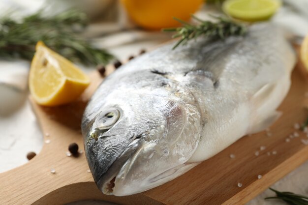 Schneidebrett mit Dorado-Fisch und Kochzutaten auf Weiß