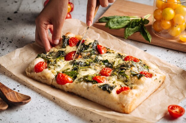 Schneiden italienische Topping Brot Focaccia mit Spinat und Tomaten