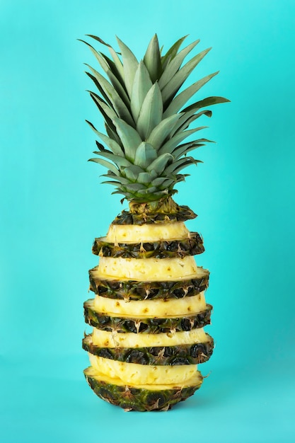 Schneiden Sie Ananas auf einem hellen Blau