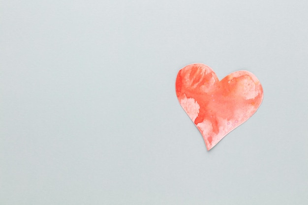 Schneiden Sie das herzförmige Papier aus und legen Sie es auf einen pastellfarbenen Hintergrund. Valentinstag-Konzepte