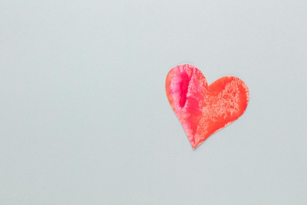 Schneiden Sie das herzförmige Papier aus und legen Sie es auf einen pastellfarbenen Hintergrund. Valentinstag-Konzepte