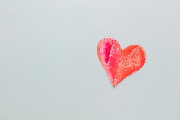 Schneiden Sie das herzförmige Papier aus und legen Sie es auf einen pastellfarbenen Hintergrund. Valentinstag Konzepte