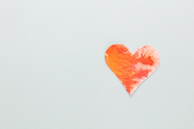 Schneiden Sie das herzförmige Papier aus und legen Sie es auf einen pastellfarbenen Hintergrund. Valentinstag-Konzepte