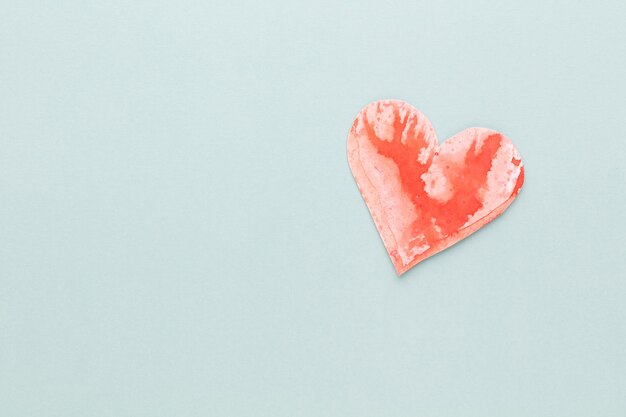 Schneiden Sie das herzförmige Papier aus und legen Sie es auf einen pastellfarbenen Hintergrund. Valentinstag-Konzepte