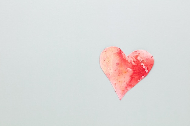 Schneiden Sie das herzförmige Papier aus und legen Sie es auf einen pastellfarbenen Hintergrund. Valentinstag-Konzepte