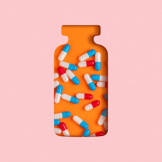 Schneiden Sie die Silhouette der Flasche mit farbigen Pillen auf orangefarbenem Hintergrund aus