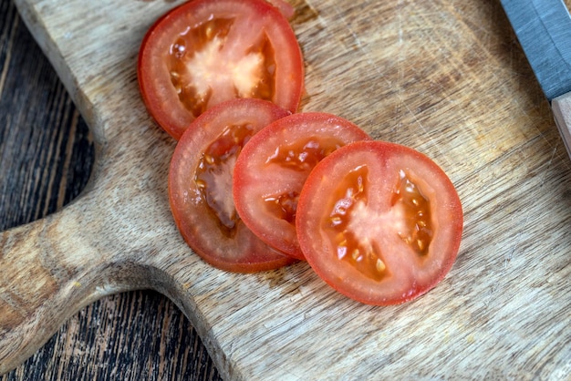 Schneiden Sie die Tomate in Stücke, während Sie den Salat kochen