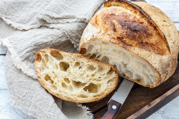 Schneiden Sie einen Laib handwerkliches Brot auf Sauerteig