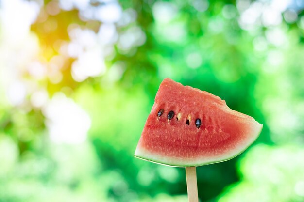 Schneiden Sie frische saftige Wassermelone auf einem hölzernen braunen Schreibtisch oder einer Tabelle