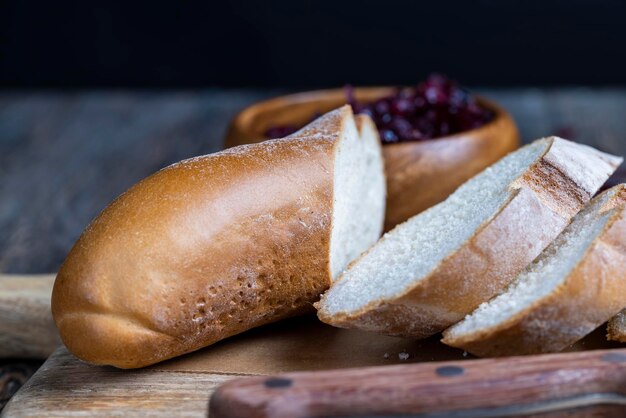 Schneiden Sie frisches Weizenbaguette in mehrere Stücke geschnittenes weiches frisches Baguette auf einem Schneidebrett und Tisch