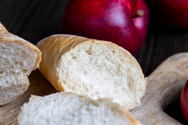 Schneiden Sie frisches Weizenbaguette in mehrere Stücke geschnittenes weiches frisches Baguette auf einem Schneidebrett und Tisch