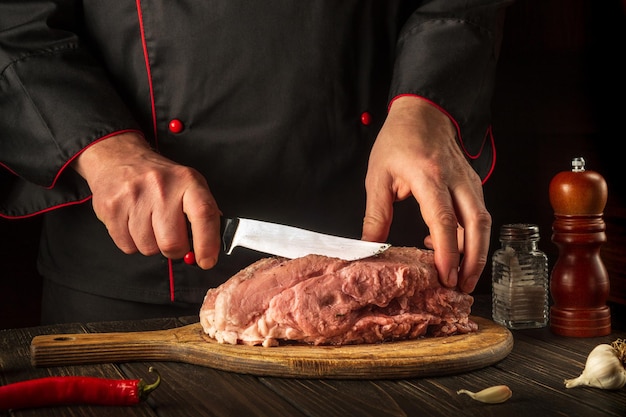 Schneiden Sie rohes Fleisch mit einem Messer, bevor Sie es in der Küche grillen