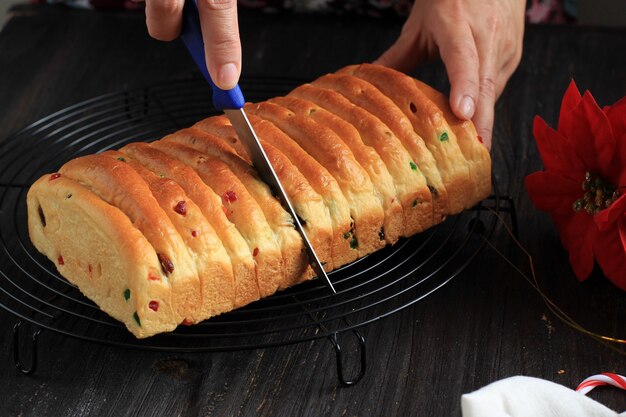 Schneiden von frisch gebackenem christstollen mit scharfem messer