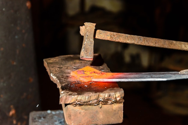 Schneiden von heißem Metall in der Schmiede.