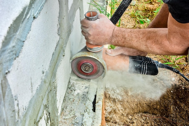 Schneiden von Mauerwerk mit Winkelschleifer und Betontrennsäge, elektrisches Handwerkzeug zum Trockenschneiden