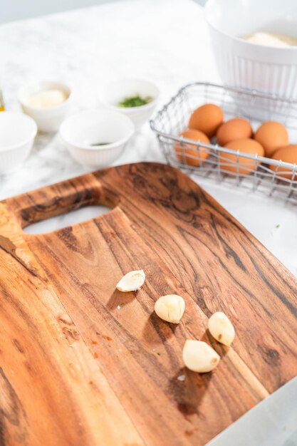 Schneiden von Zutaten auf einem Holzschneidebrett, um Zucchini-Kuchen zu machen.