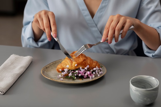 Foto schneidendes croissant mit hohem winkel für erwachsene