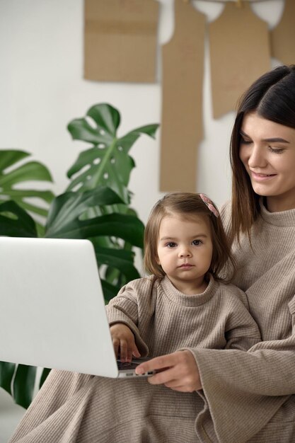 Schneiderin, die mit ihrer Tochter in ihrem Atelier Kleider herstellt