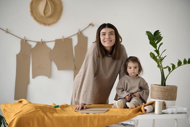 Schneiderin, die mit ihrer Tochter in ihrem Atelier Kleider herstellt