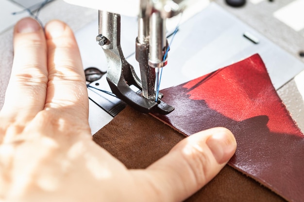 Schneiderin näht Leder auf Nähmaschine