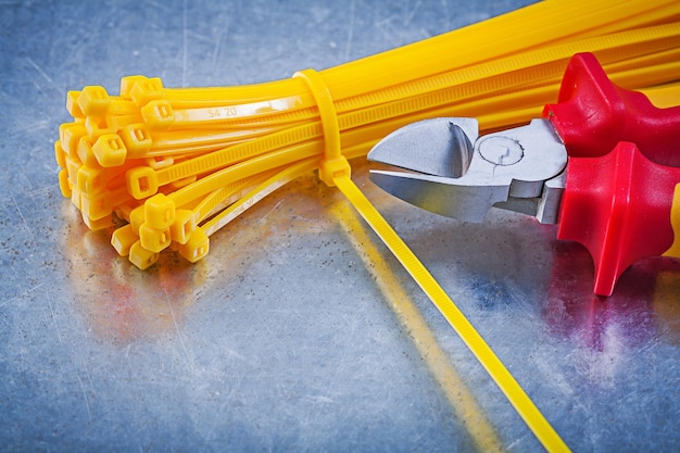 Schneidezange Kabelbinder auf metallischem Hintergrund Baukonzept