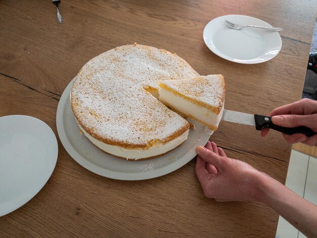 Foto schnitt aus einem cremigen käsekuchen, den meine frau selbst gebacken hat