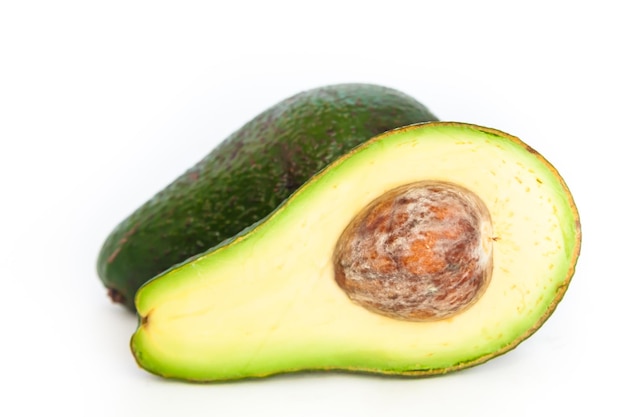 Schnitt und ganze reife Avocados auf weißem Hintergrund