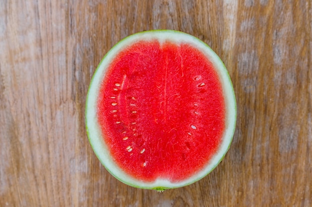 Schnitt zur Hälfte Wassermelone auf alten Holztisch