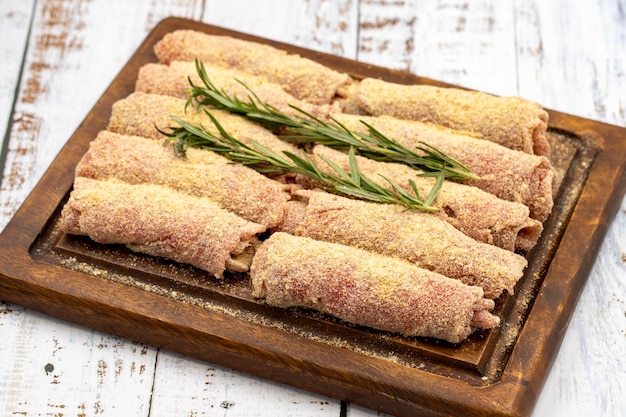 Schnitzel de carne em fundo de madeira Delicioso schnitzel de carne crua preparado com pão ralado e gergelim branco