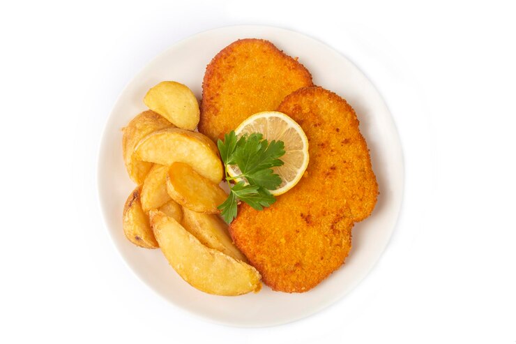 Foto schnitzel de frango com molho de batatas fritas e limão em um prato
