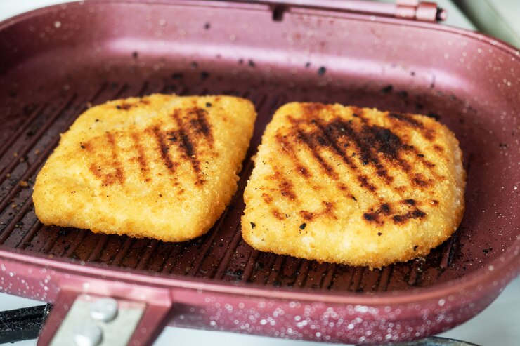 Schnitzel frito a la parrilla. Dos piezas de Cordon Bleu con jamón y queso en una sartén.
