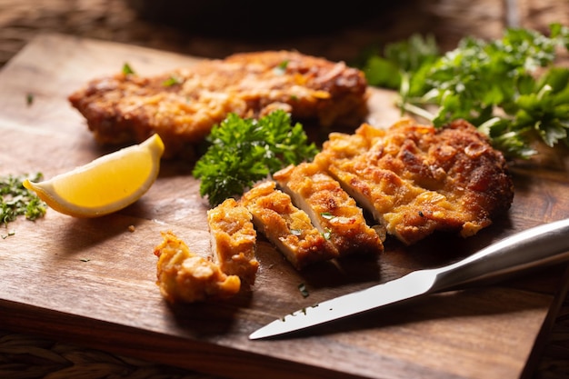 Schnitzel de pollo vienés tradicional sobre una tabla de madera.