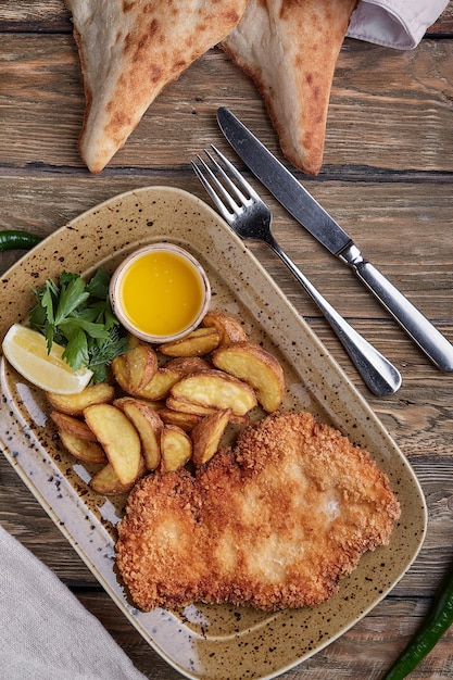 Schnitzel saboroso com batata cozida Vista superior comida plana leiga