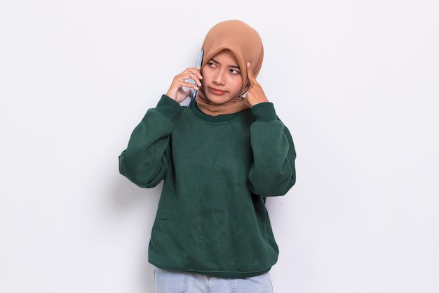 Schock und traurige junge asiatische schöne muslimische Frau mit Handy isoliert auf weißem Hintergrund