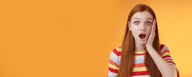 Schockiert beeindruckt besorgt Ginger Mädchen Kiefer fallen keuchen betäubt Schlag Wange breit Augen überrascht hören