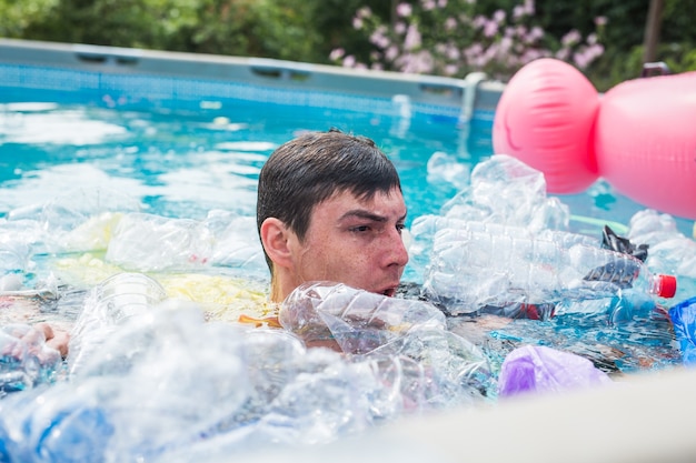 schockierter mann schwimmt in einem schmutzigen schwimmbad.