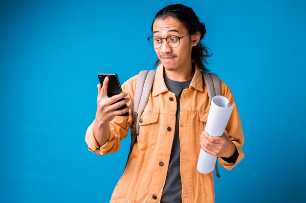 Schockierter und überraschter Mann, der auf Smartphone schaut